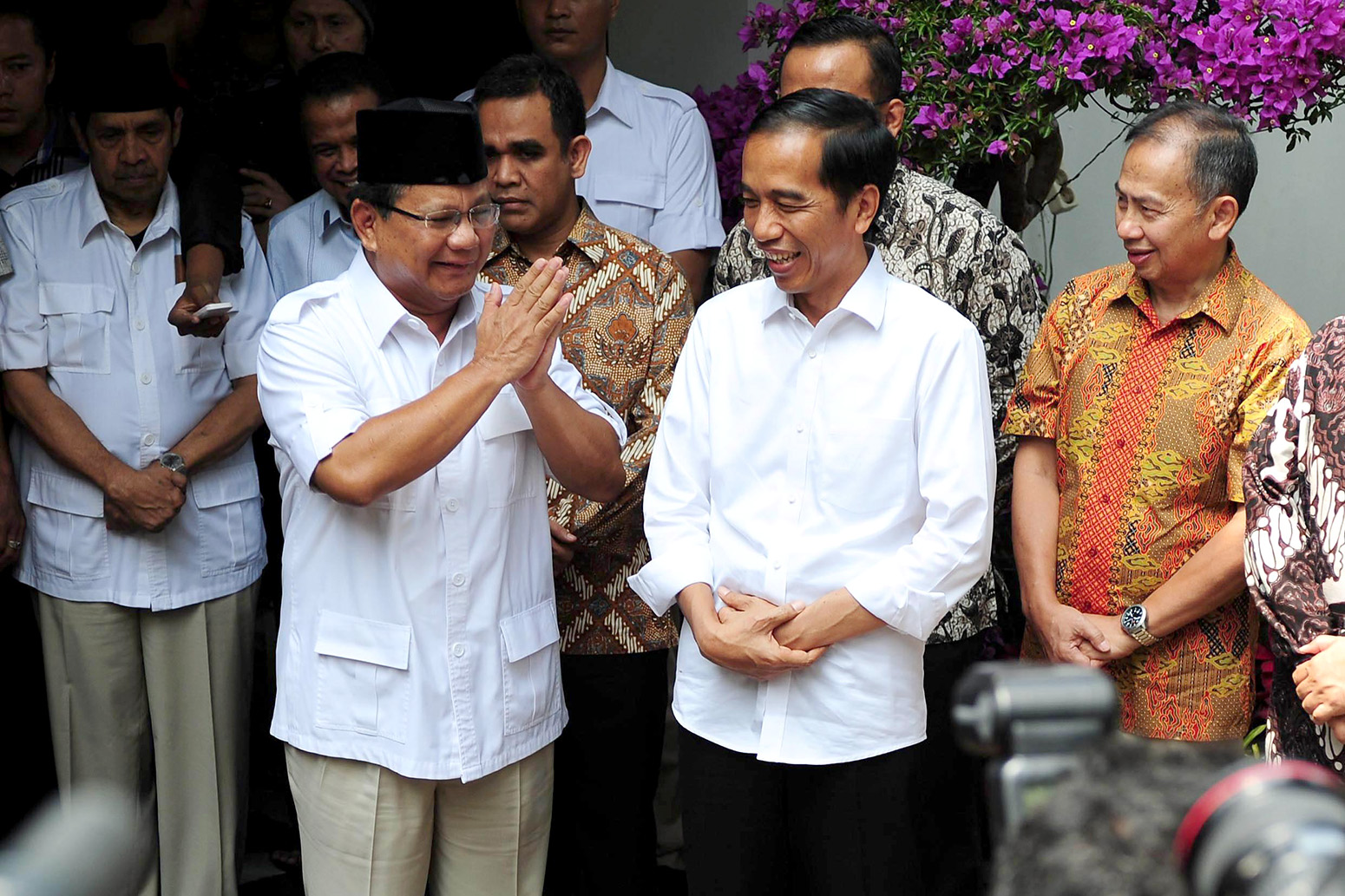 Presiden Indonesia Joko Widodo (kedua dari kanan) dan rivalnya yang seorang mantan jenderal Prabowo Subianto (kiri depan) berbicara kepada media setelah pertemuan di Jakarta, 17 Oktober 2014. Kredit: Xinhua / Alamy Stock Photo.